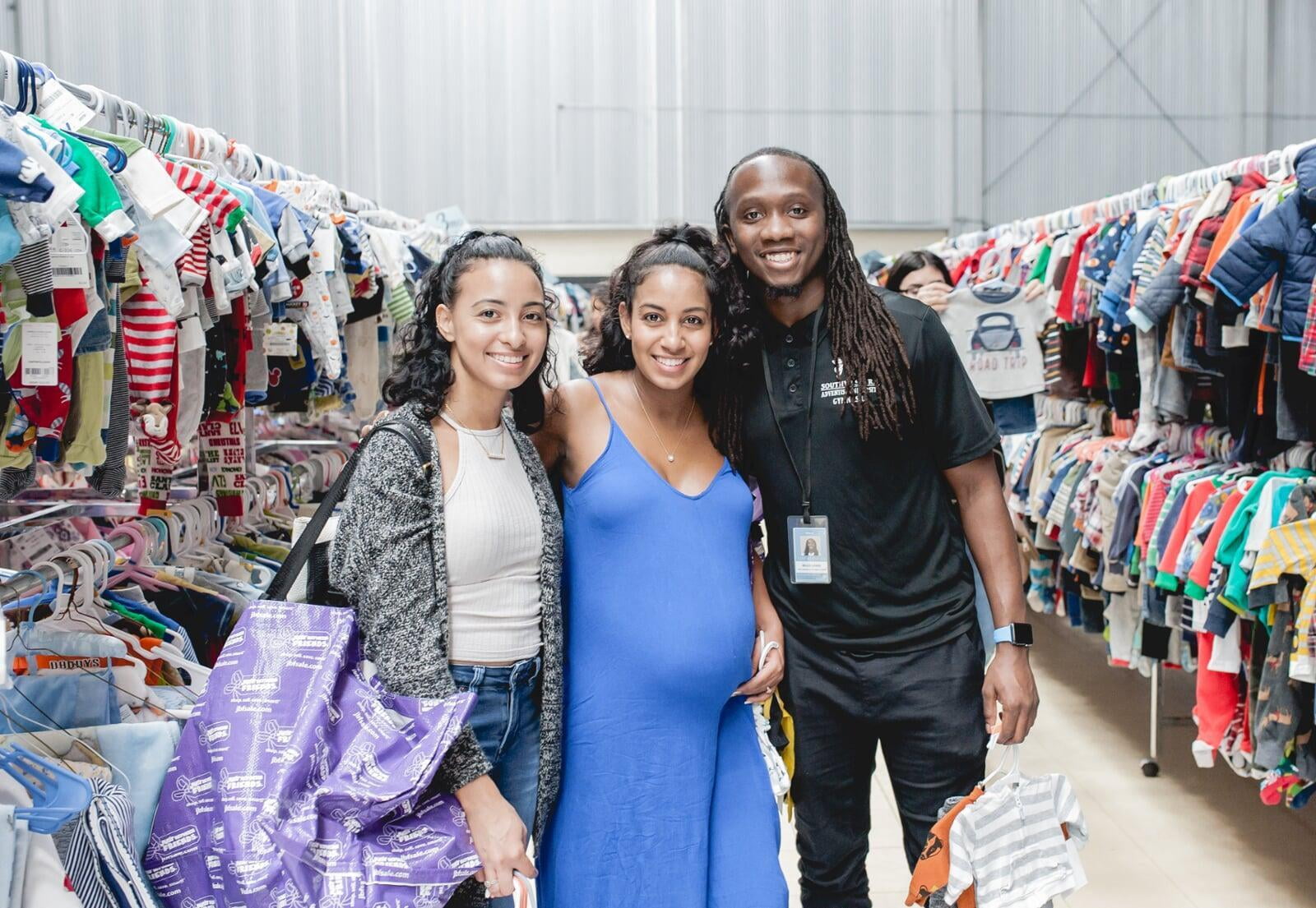 A mom and her two kids stand in the shoe section for a happy family photo.